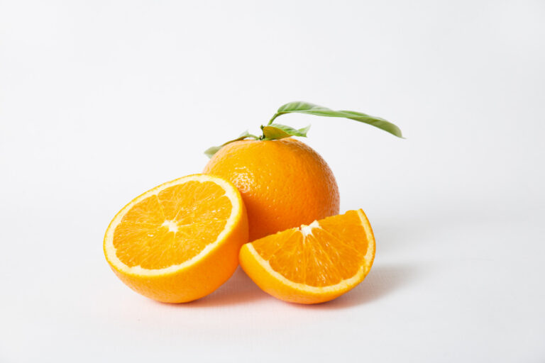 cut orange parts whole fruit with green leaves