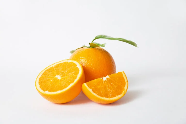 cut orange parts whole fruit with green leaves