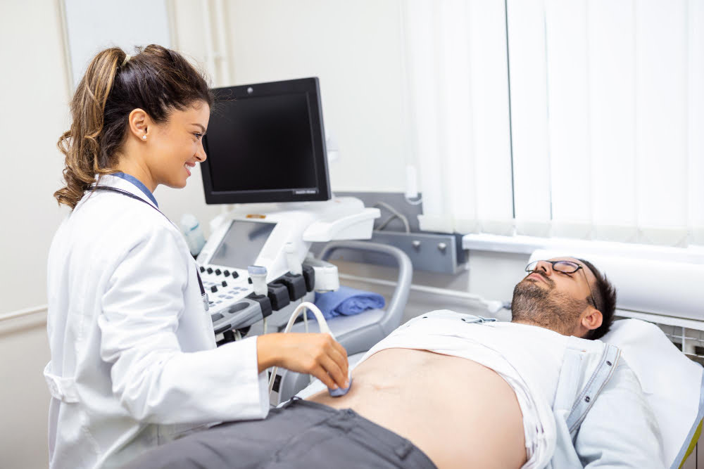 Ultrassom: Tecnologia para Diagnóstico e Tratamento 4 careful female doctor white coat sitting front ultrasound apparatus conducting abdominal diagnostics with transducer