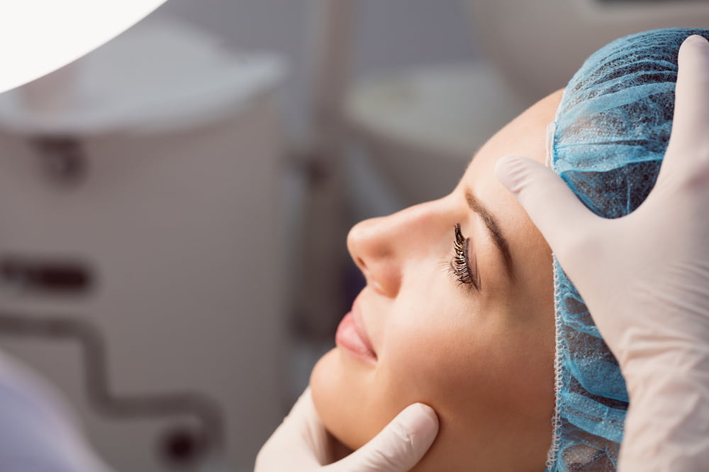 Quanto tempo leva para se recuperar de uma rinoplastia? 2 doctor examining womans face cosmetic treatment 1